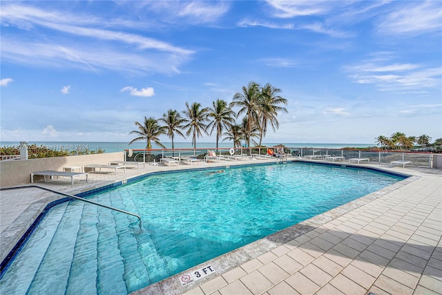 view of pool with a water view and a patio