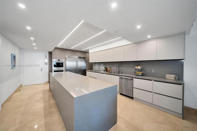 kitchen with a large island, sink, appliances with stainless steel finishes, and white cabinets