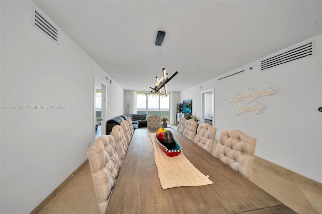 dining space featuring light hardwood / wood-style floors and a notable chandelier