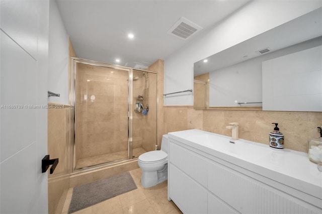 bathroom featuring an enclosed shower, toilet, tile walls, vanity, and tile patterned flooring