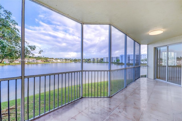 unfurnished sunroom featuring a water view