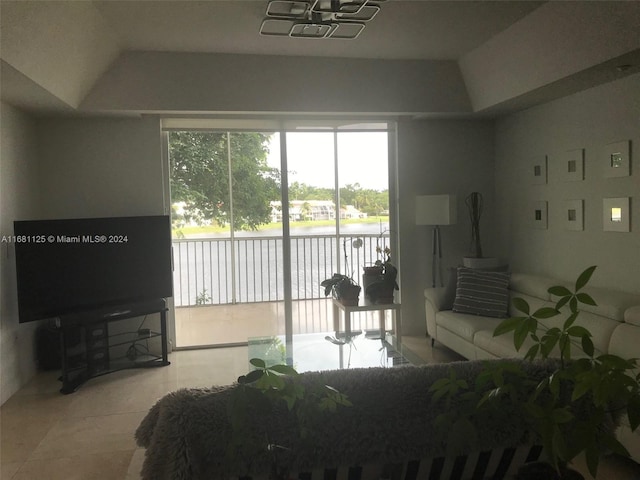 tiled living room with a water view and vaulted ceiling