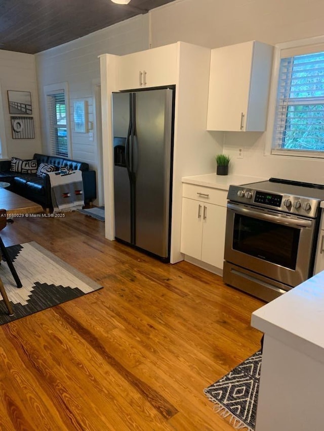 kitchen with a wealth of natural light, light wood finished floors, stainless steel appliances, and light countertops