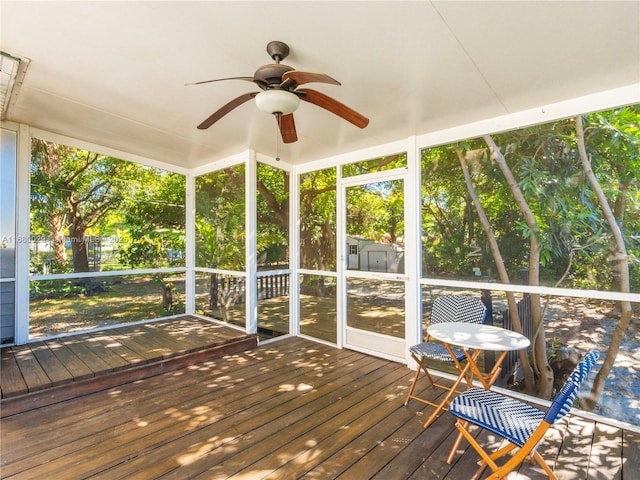 unfurnished sunroom with ceiling fan