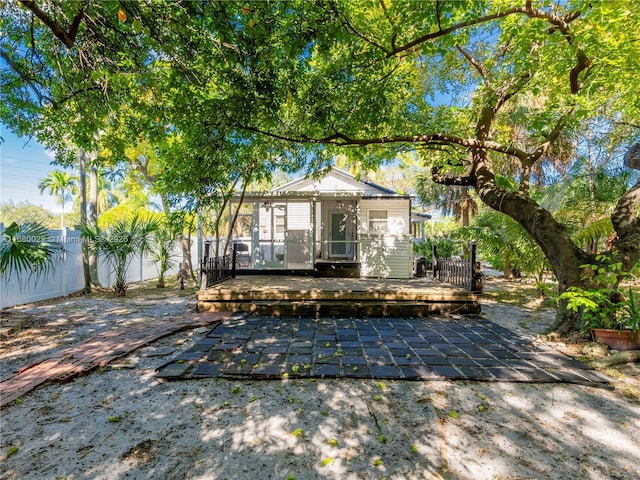 view of front facade featuring a patio area, a deck, and fence