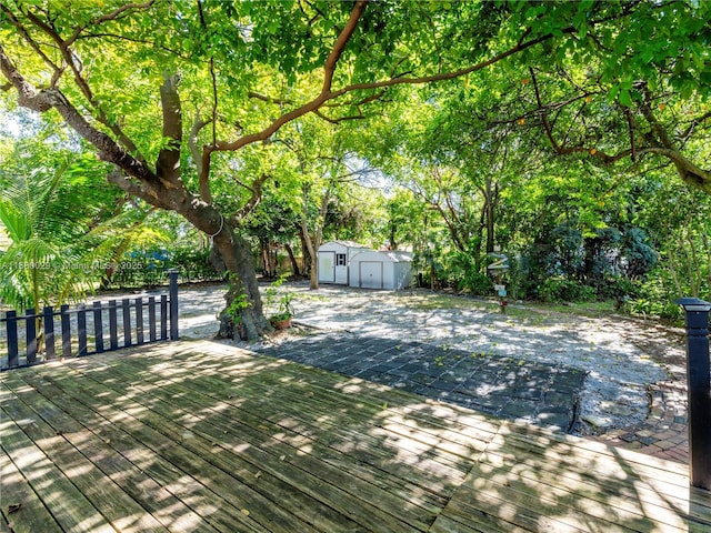 wooden deck featuring a storage shed and an outbuilding