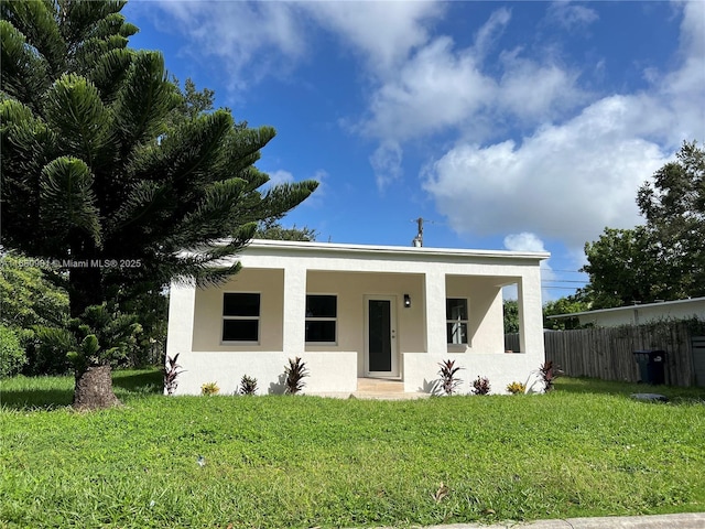 view of front of home featuring stucco siding, a porch, a front lawn, and fence
