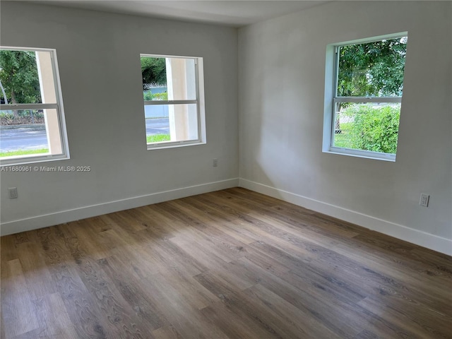 spare room featuring hardwood / wood-style floors and plenty of natural light