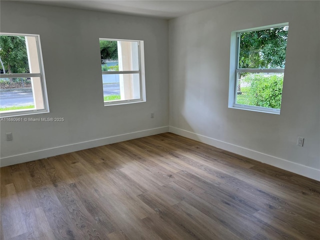 empty room featuring wood finished floors and baseboards