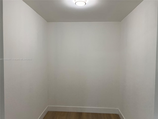 unfurnished room featuring baseboards and wood finished floors