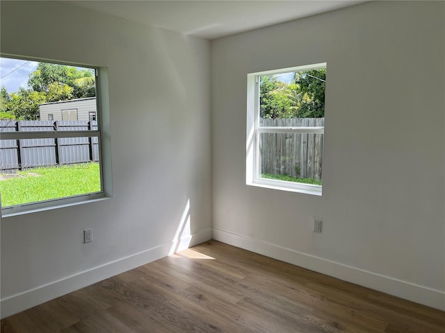 empty room with baseboards and wood finished floors