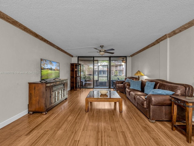 living room with ceiling fan, light wood-type flooring, crown molding, and a textured ceiling