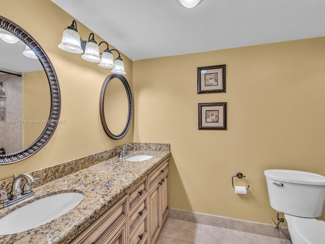 bathroom with toilet, vanity, and tile patterned floors