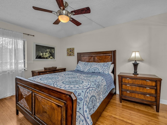 bedroom featuring ceiling fan, a textured ceiling, and light hardwood / wood-style flooring