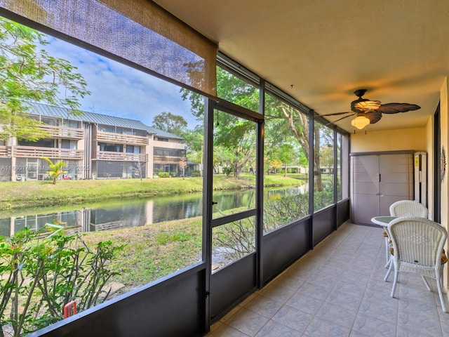 sunroom with a water view and ceiling fan