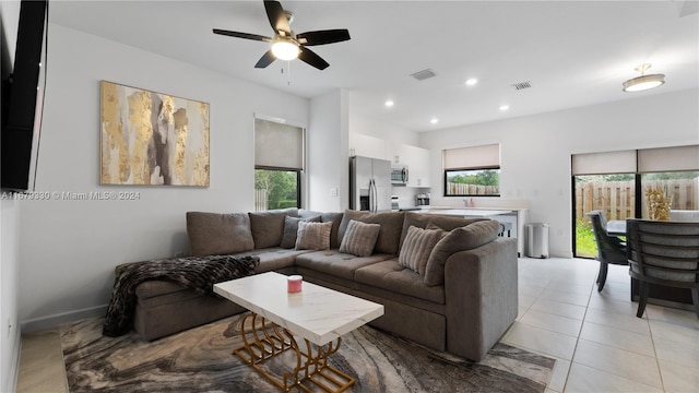 tiled living room with ceiling fan and a wealth of natural light