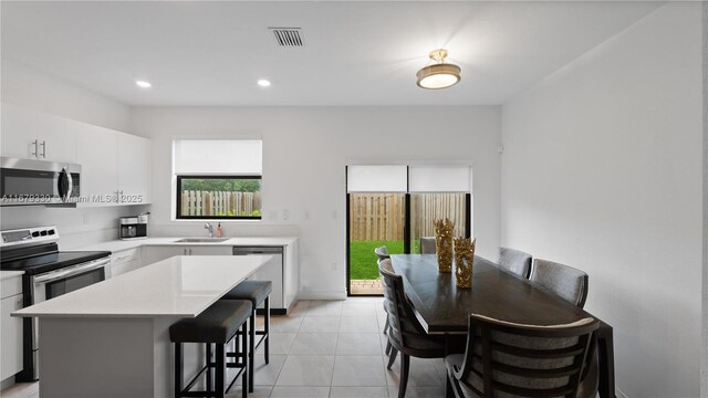 kitchen featuring a center island, white cabinetry, stainless steel appliances, and sink