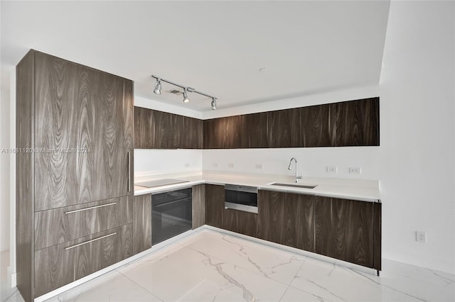 kitchen with sink, rail lighting, and black appliances