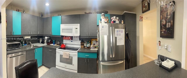 kitchen featuring sink, appliances with stainless steel finishes, backsplash, and light tile patterned flooring