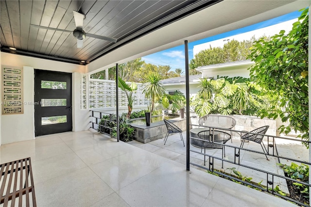 sunroom with ceiling fan and wooden ceiling