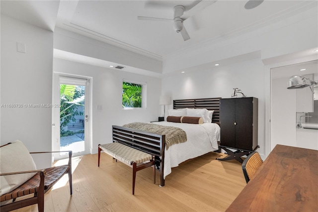 bedroom with ceiling fan, a tray ceiling, light hardwood / wood-style flooring, and access to exterior