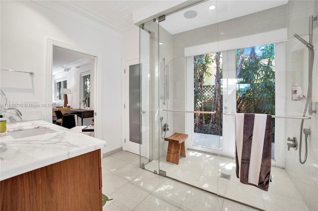 bathroom featuring vanity, ornamental molding, and a shower with door