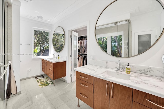 bathroom with vanity, ornamental molding, and a healthy amount of sunlight