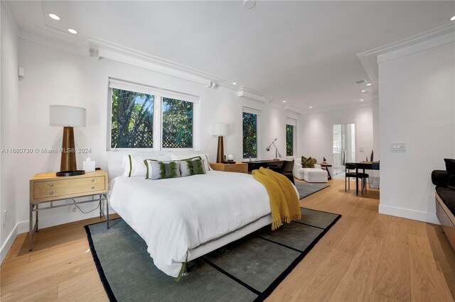 bedroom featuring crown molding and light hardwood / wood-style flooring