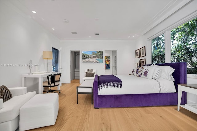 bedroom with crown molding and light hardwood / wood-style floors