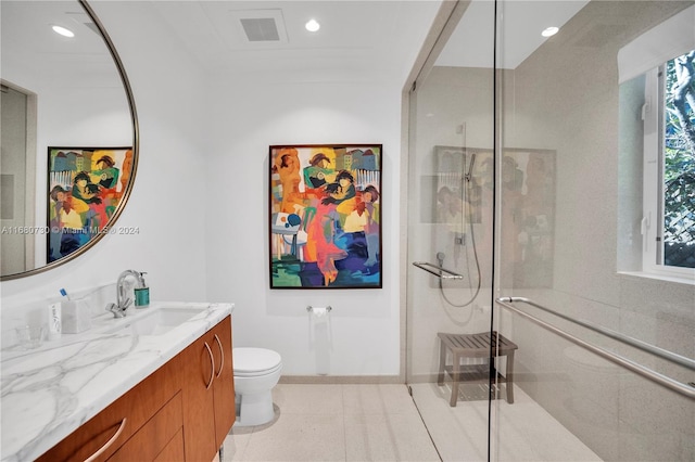 bathroom with vanity, toilet, and a shower with door