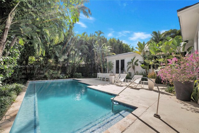 view of pool with french doors and a patio area