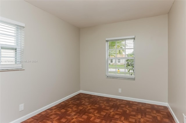 empty room with dark parquet flooring