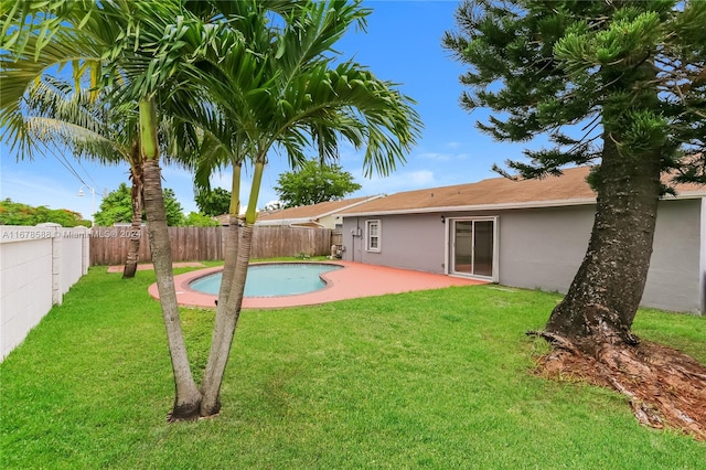 view of swimming pool featuring a patio and a yard