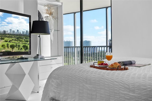 bedroom with floor to ceiling windows and a water view