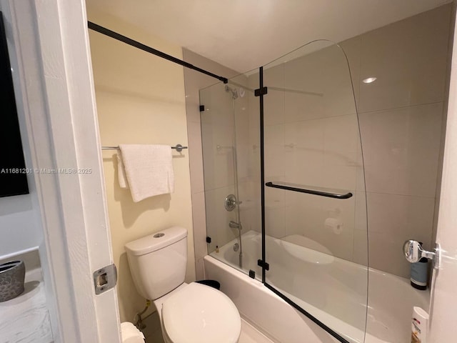 bathroom with toilet and bath / shower combo with glass door