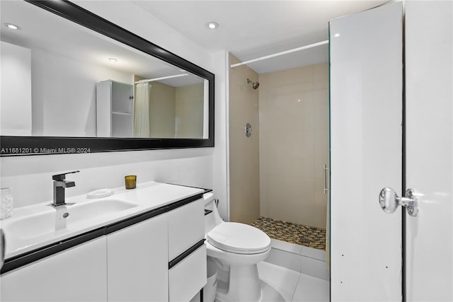 bathroom featuring tile patterned flooring, vanity, toilet, and walk in shower