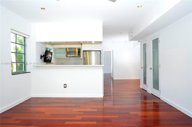 kitchen with kitchen peninsula, stainless steel appliances, and dark hardwood / wood-style flooring