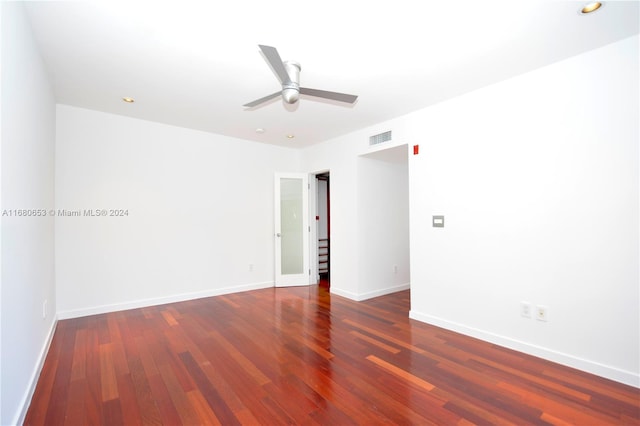 empty room featuring dark wood-type flooring and ceiling fan