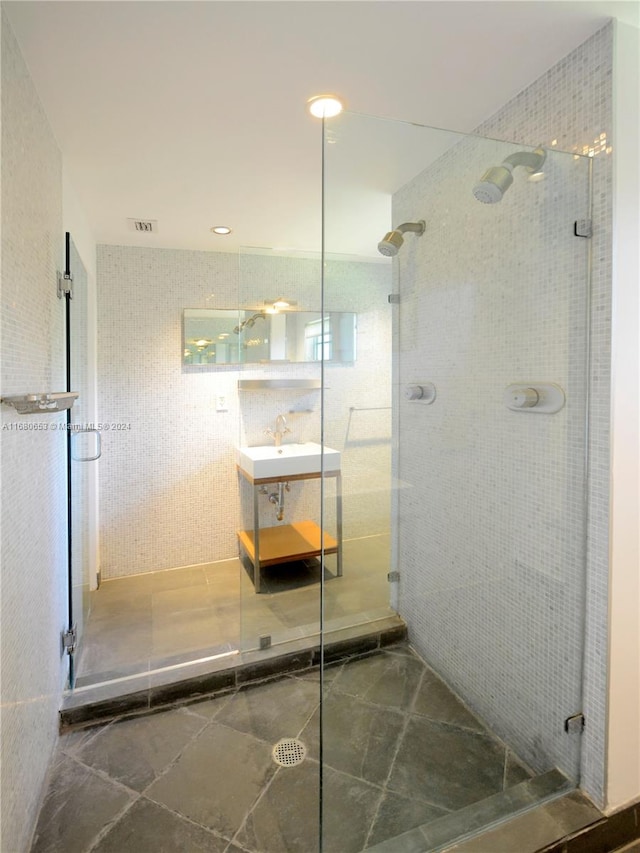 bathroom with sink and a shower with shower door