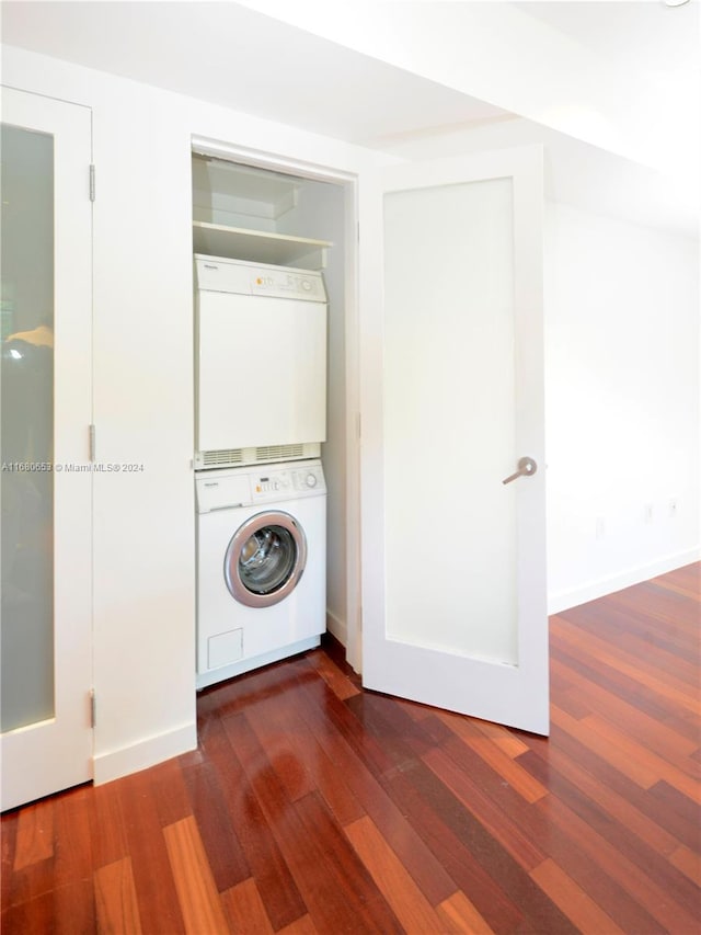 washroom featuring stacked washer and dryer and dark hardwood / wood-style floors