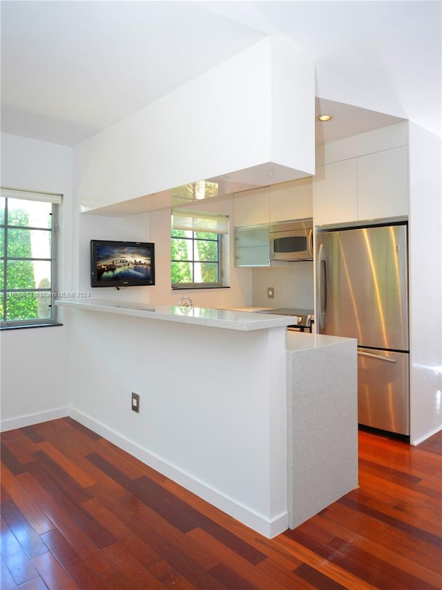 kitchen with white cabinets, stainless steel appliances, dark wood-type flooring, and plenty of natural light