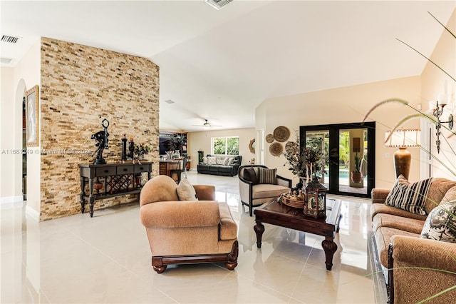 tiled living room featuring french doors, ceiling fan, and vaulted ceiling