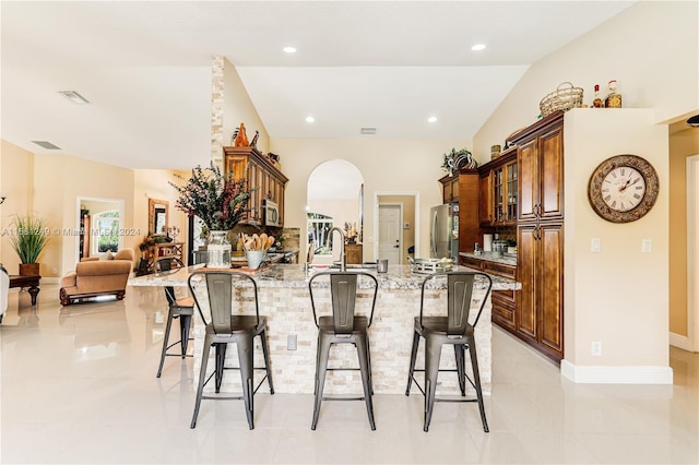 12288 N 82nd Ln N, West Palm Beach, FL 33412 - kitchen featuring a kitchen bar, a peninsula, arched walkways, stainless steel appliances, and recessed lighting