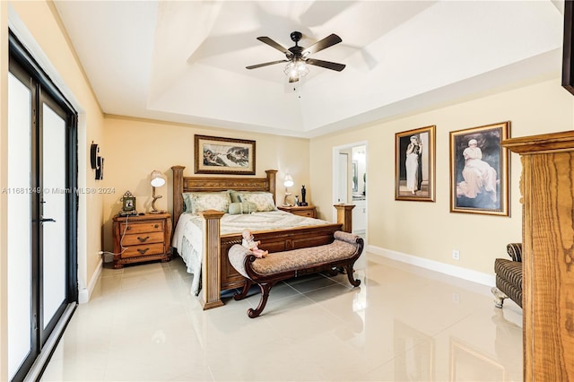 tiled bedroom with ceiling fan and a raised ceiling