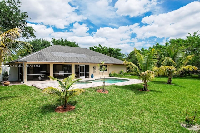 rear view of house with a lawn and a patio