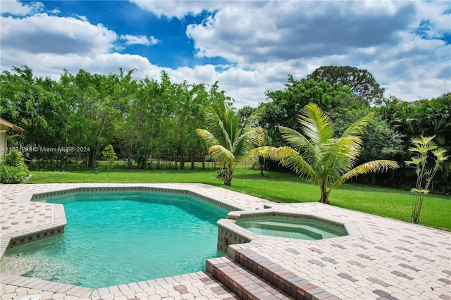 view of swimming pool with a lawn and an in ground hot tub