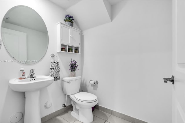 bathroom featuring tile patterned floors, sink, vaulted ceiling, and toilet