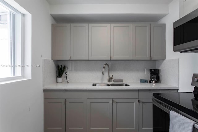 kitchen with a healthy amount of sunlight, sink, electric range, and gray cabinetry