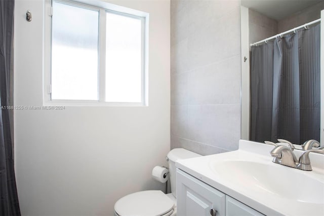 bathroom with toilet, curtained shower, and vanity