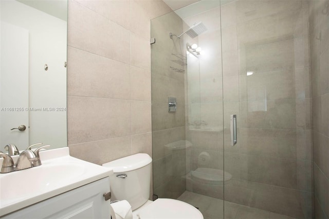 bathroom featuring vanity, a shower with shower door, and toilet